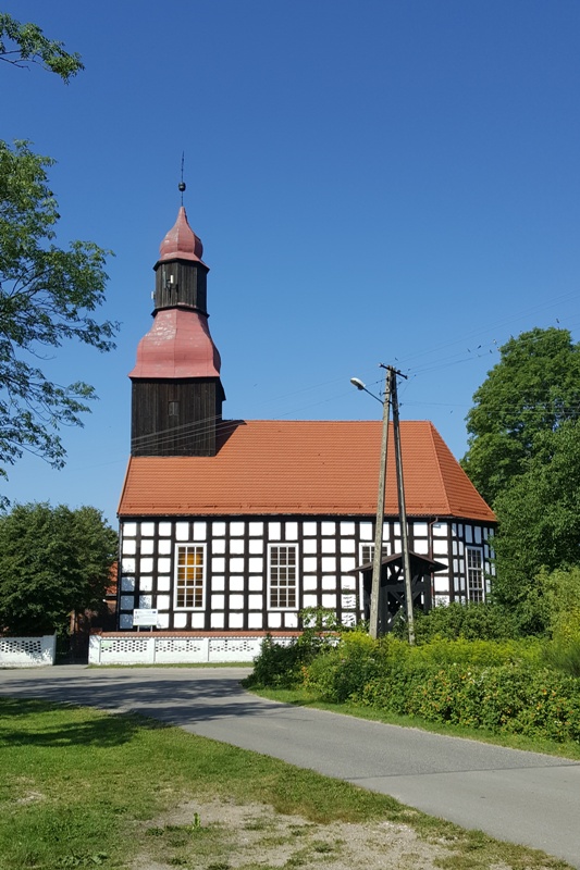 Kościół szachulcowy z wieżą, przykryty czerwoną dachówką